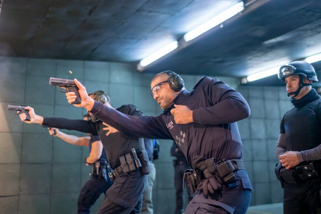 Police training in shooting gallery with short weapon.